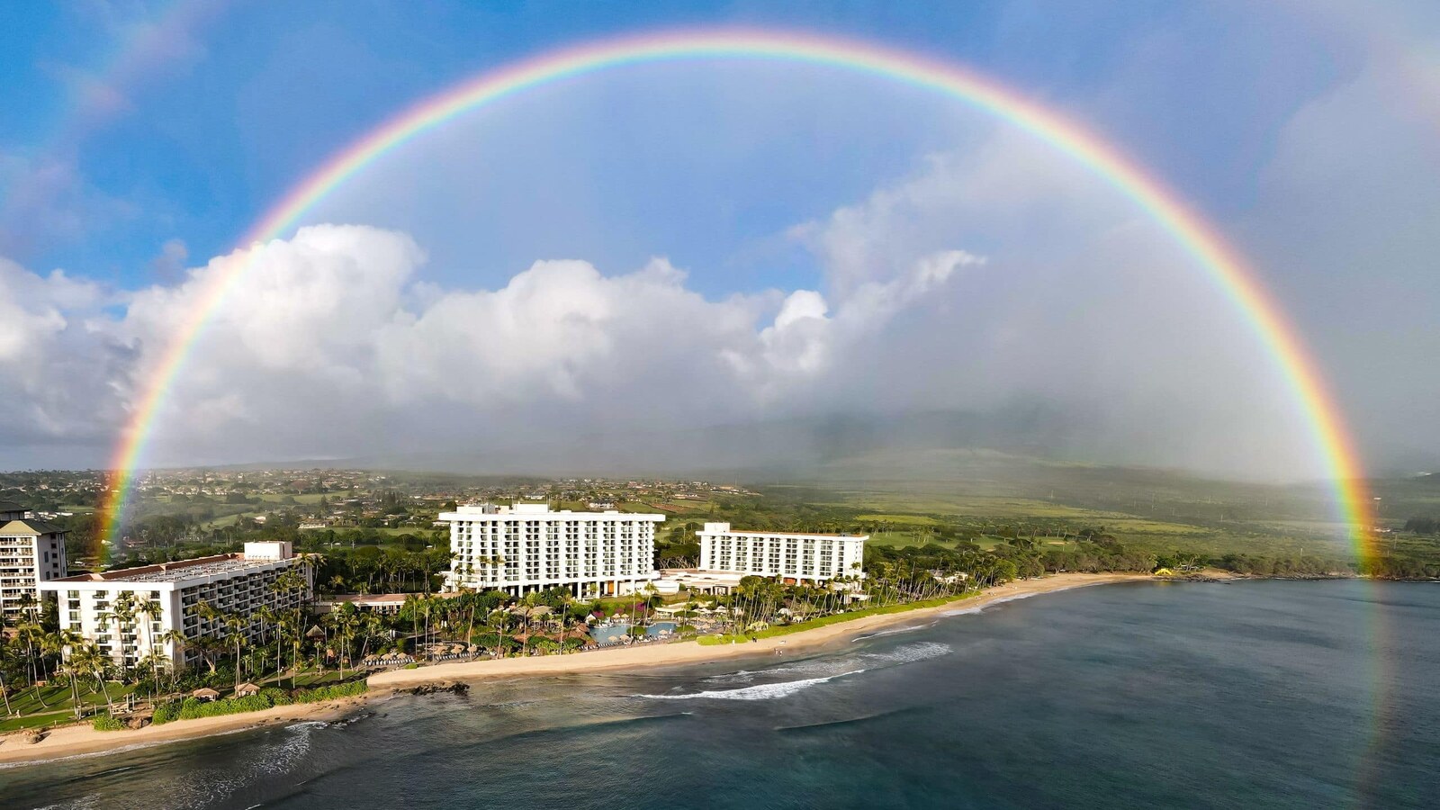 Rainbow arching over the Maui shoreline and 2027 customer trip resort